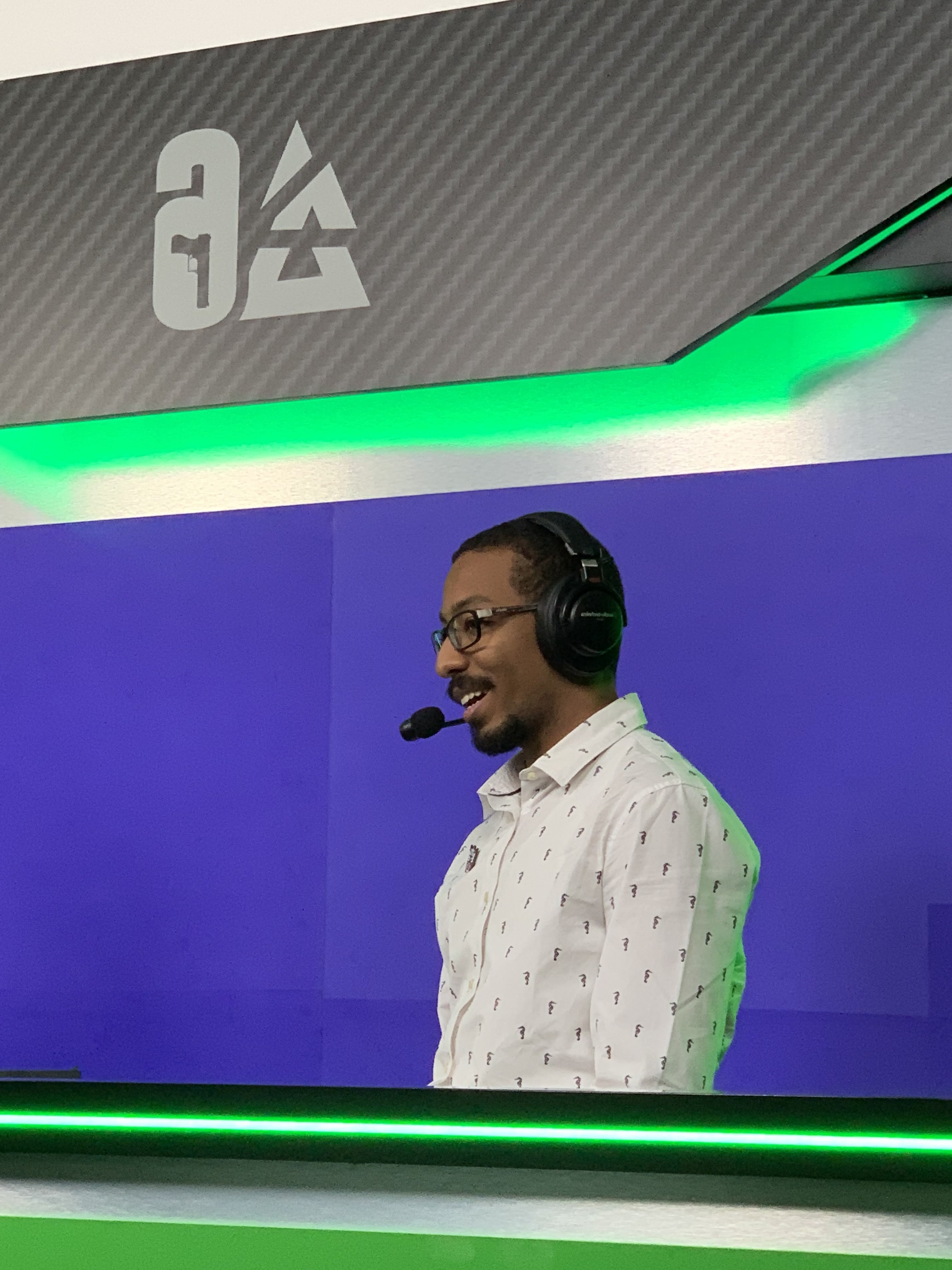 Mostafa wearing a headset talking and smiling